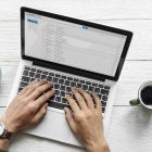 Aerial view of a man using computer laptop on wooden table